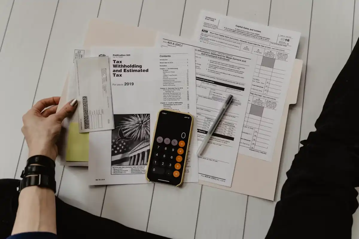Person reviewing financial documents and a calculator at a desk